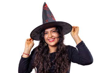 Fototapeta premium Young hispanic woman in a playful witch costume and black pointy hat, smiling and posing for a festive halloween studio portrait on a clean white background