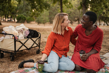 Two smiling friends enjoying a picnic in a park