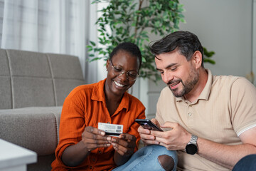 Couple shopping online using credit card and smartphone at home