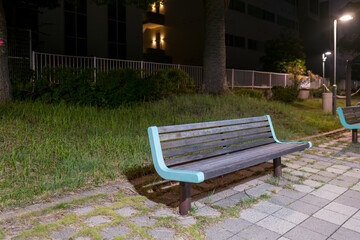 夜の街灯に照らされた公園のベンチ