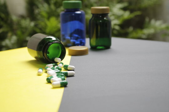 Capsulas para la salud saliendo de un recipiente con un fondo desenfocado 