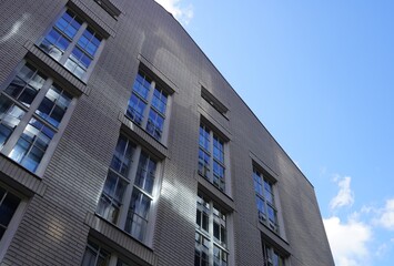 Beautiful modern building facade reflecting sky and clouds on a sunny day