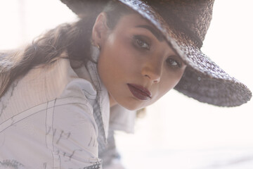 Portrait of a stylish woman in a hat with soft, natural light. Represents elegance, confidence, mystery, and timeless beauty