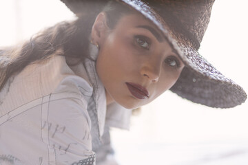 Portrait of a stylish woman in a hat with soft, natural light. Represents elegance, confidence, mystery, and timeless beauty