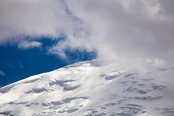 A close-up of a mountain peak in bad weather, leading to the death of climbers in windy weather, snow-capped peaks in the clouds