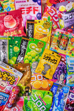 osaka, kanzaki - sep 19 2025: Top-down photography showcasing colorful and whimsical japanese gummy and candy packaging by uha mikakuto, evoking nostalgic pop culture charm through playful design.