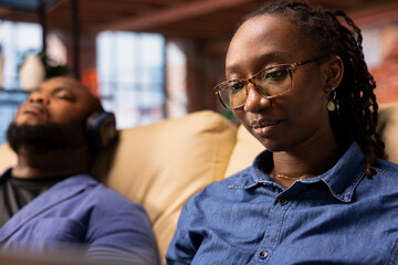 Tech savvy user working on a wireless laptop to test a new software, navigating new digital tools and managing virtual tasks. Connected and productive lifestyle from her home, living room space.