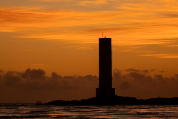 Golden sunrise in Itacaré, Bahia, Brazil. Boats floating on calm sea, yellow light on the horizon, tropical coastal landscape with warm tones and natural beauty.