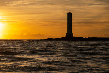 Golden sunrise in Itacaré, Bahia, Brazil. Boats floating on calm sea, yellow light on the horizon, tropical coastal landscape with warm tones and natural beauty.