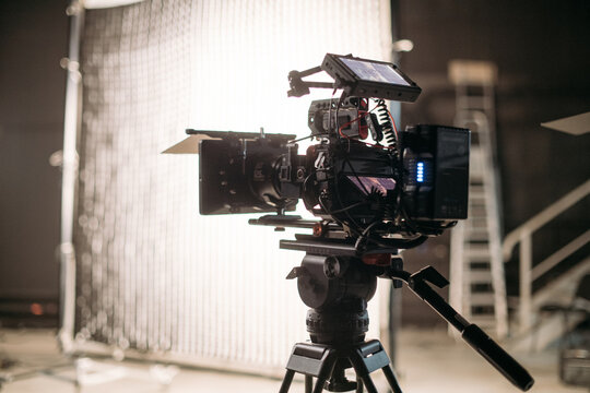 Professional film and video cameras on the set. Filming crew, lighting equipment, professional filming equipment and crew. Methods of modern film production and advertising.
