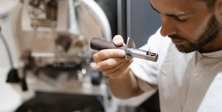 Young caucasian male test of roasting coffee beans using professional equipment