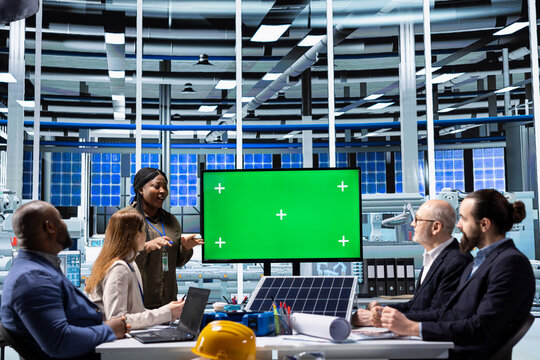 Photovoltaics plant shareholders assessing deal feasibility and project returns using mockup display. Investors in solar panels factory office performing financial analysis using green screen monitor
