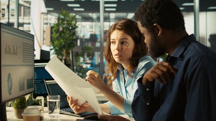 Team leader working together with bookkeeper to read and verify accuracy of business documents....