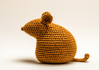 A crocheted brown mouse, showcasing its unique texture and design. This handmade creation is a testament to craft and creativity