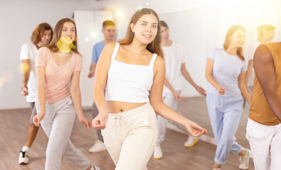 Naklejka premium Group of energetic different people learning dance at dance class