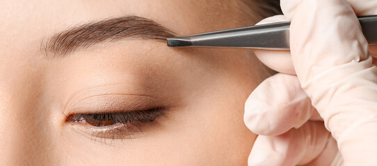 Young woman undergoing eyebrow correction procedure, closeup