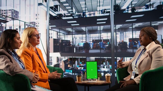 Group of businesswomen using green screen mockup on tablet in a briefing meeting, exchanging ideas and details about a future project. Ambitious female leaders planning a strategy. Camera B. - Powered by Adobe