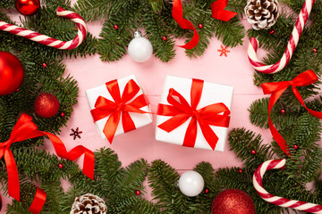 Festive Christmas tree branches with gift box on wooden background, top view