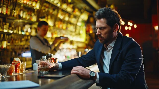 Lonely man drinking bourbon at bar counter closeup. Depressed guy life problems