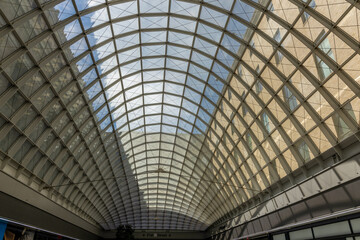 Roof beams and glass ceiling in Moynihan Train Hall at Penn Station in New York City.