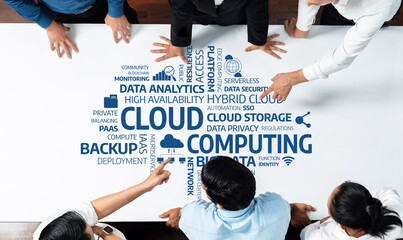 A diverse group of professionals collaborates over a table displaying cloud computing concepts, focusing on data analytics, cloud storage, and modern technology solutions. Amity