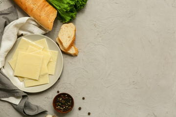 Plate with slices of delicious processed cheese and bread on grey grunge table