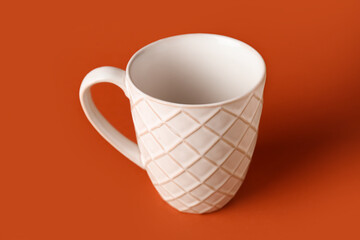 White ceramic cup on orange background