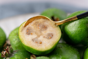Extreme close-up of a feijoa with a golden spoon