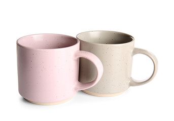 Stylish ceramic mugs isolated on white background