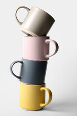 Stack of different ceramic mugs on grey background