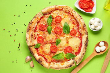 Tasty pizza Margarita and ingredients on green background