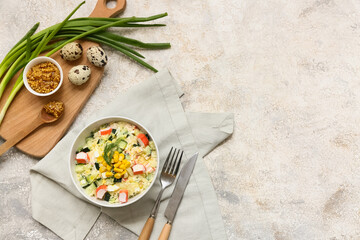Bowl of salad with crab sticks, corn, cucumber and ingredients on light grunge background © Pixel-Shot
