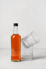 Bottle of rum and glasses on white background