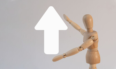 Concept of Progress: A wooden mannequin shows an upward arrow.