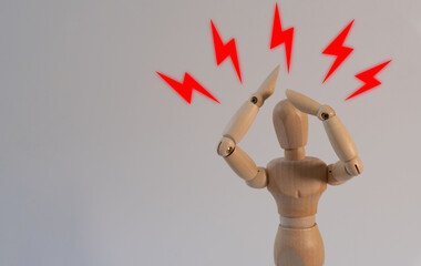 Stress concept: a wooden mannequin in a stressed and sad pose with red rays around it