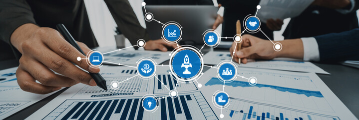 Analyst team working on BI Fintech to analyze financial dashboard paper at office workplace. Businesspeople reviewing report paper on table for business insight. Panorama shot. Prodigy Amity