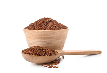 Wooden bowl and spoon with raw brown rice on white background
