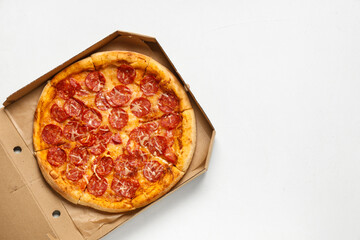 Cardboard box with tasty pizza on white background