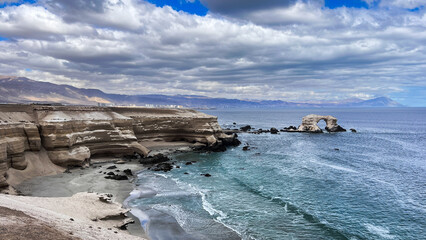 Landscape view over Pacific Coast with impressive natural arch called  ''Monumento Natural La Portada'' located  near Antofagasta in Chile. The natural bridge rock formation is  tourist attraction.