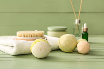 Composition with towel and bath bombs on green wooden background, closeup