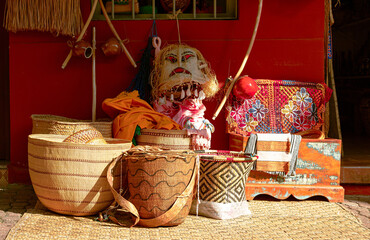 Colorful display of handmade crafts, baskets and a berimbau at the storefront of a traditional shop.