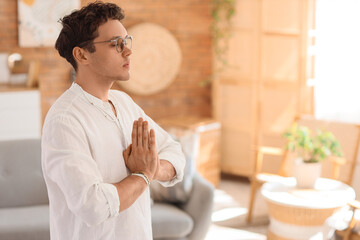 Young man meditating at home