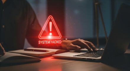 Urgent system hacked alert flashes as person frantically types on laptop