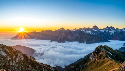 Sunrise over alpine peaks, clouds below