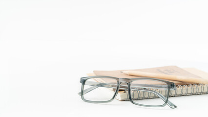 Stylish eyeglasses resting on a notebook with a pencil, ideal for back to school campaigns and educational material with a modern aesthetic