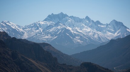 Majestic snow-capped mountains rise against a clear, vibrant sky, showcasing rugged peaks and valleys.
