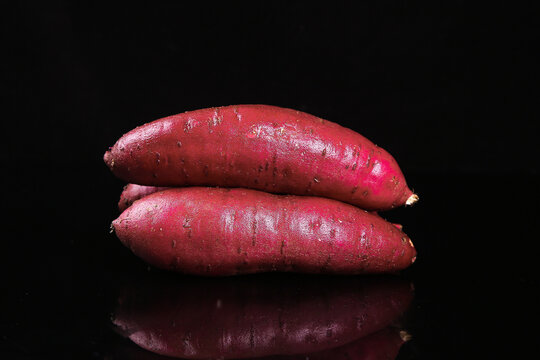 Fresh Red Sweet Potatoes on Black Background - Healthy Root Vegetable Food Photography