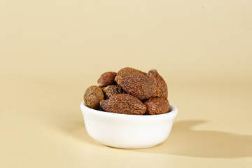 Dried Nutmeg Seeds in White Bowl - Natural Spice for Cooking and Traditional Medicine