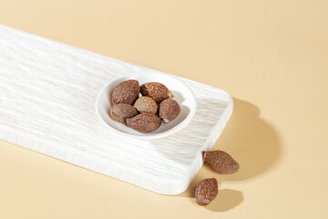 Whole Nutmeg Spices in Bowl on Wooden Board - Natural Health Ingredient for Cooking and Wellness