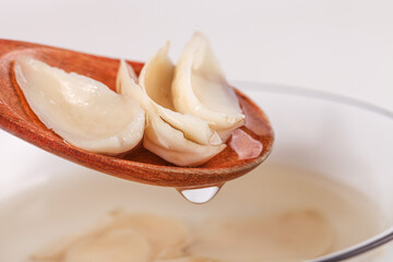 Dried Baihe Lily Bulb Chinese Herbal Medicine Closeup on Wooden Spoon Traditional Healing Tonic Ingredient